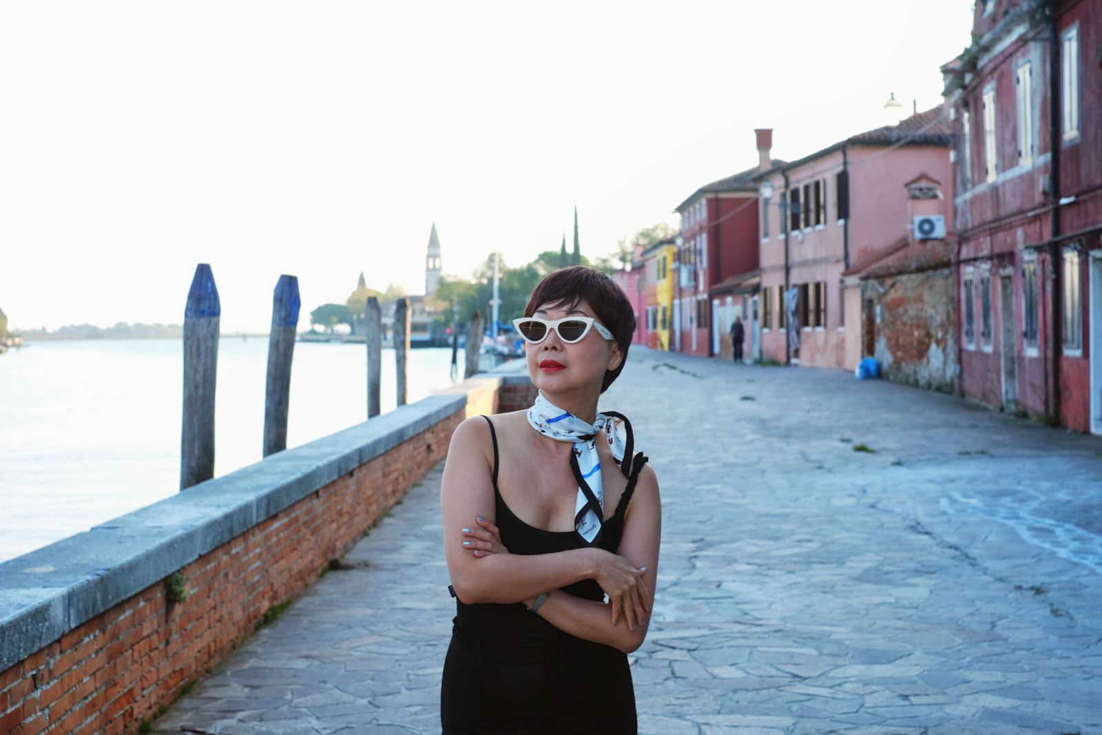 Stylish woman on the waterfront at Mazzorbo, Venice, Italy.