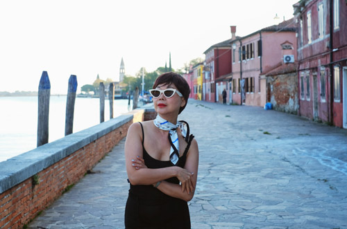 Stylish woman on the canal waterfront of Mazzorbo Venice.